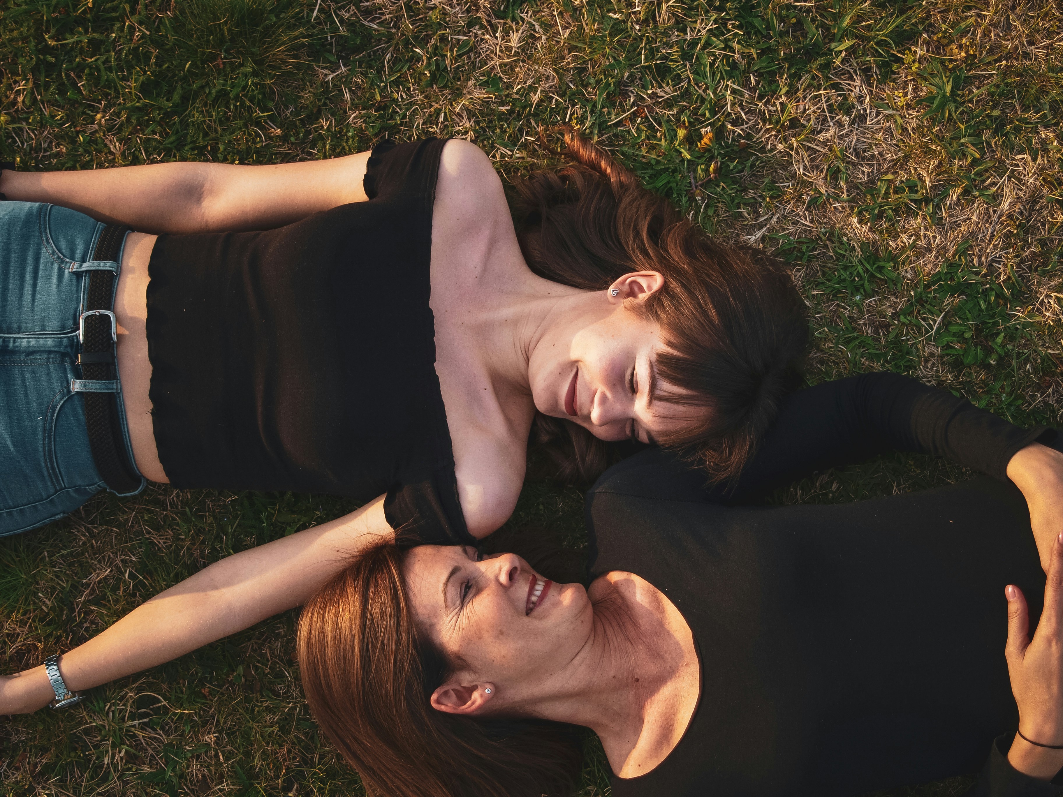 Two smiling women lying on the grass