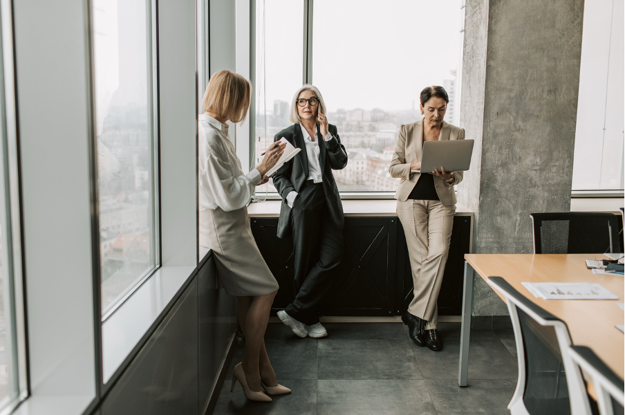 Three colleagues over 40 at work in an office: menopause support under ISO 45010